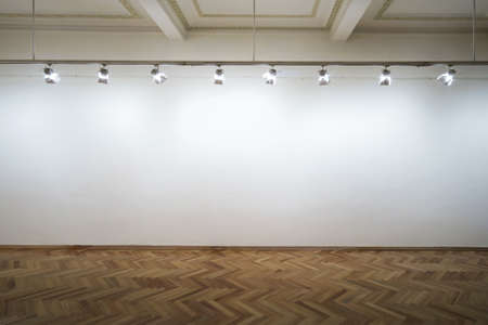 Interior of a empty white wall with spot lights at art gallery