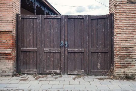 Old wooden gate with a large round metal handles