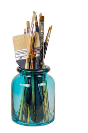 Various professional paint brushes in the green glass jar, isolated on white backgroundの写真素材