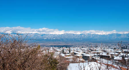 Beautiful view of Caucasus mountains from the town covered with snow