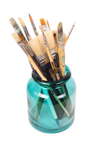 Various professional paint brushes in the green glass jar, isolated on white backgroundの写真素材