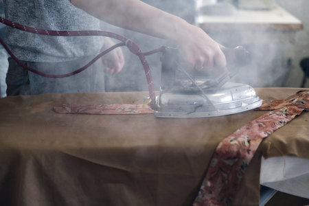 Woman's hand  ironing clothes with steaming ironの写真素材