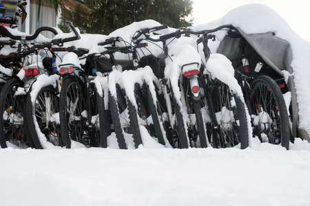 Bicycle parking at winter, row of bicycles covered with snowの写真素材