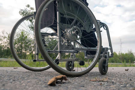 A wheelchair crossing road with overgrown roadsidesの写真素材