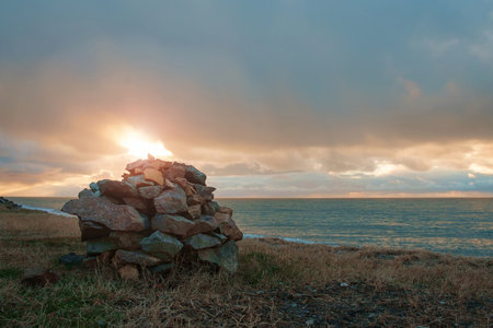 Stones amassment on the beach with sunset cloudy sky backgroundの写真素材