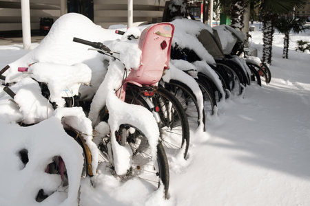 Bicycle parking at winter, row of bicycles covered with snowの写真素材