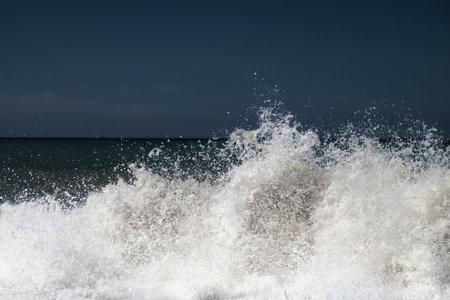 Big foamy splashing sea wave crushing to the coastの写真素材