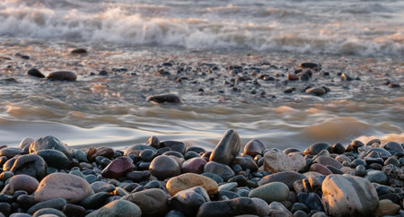 View of empty pebbles beach with splashing sea waves backgroundの写真素材