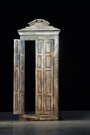 Old wooden rough door with peeled paint on dark background.の写真素材