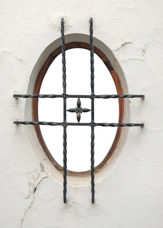 Round window with iron bars in a classic style with isolated backgroundの写真素材