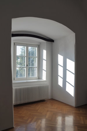 Empty interior of a old house with reflections of sunlight through the window with blindsの写真素材