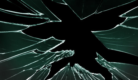 Cracked and broken glass with hole on a black background
