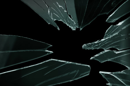 Cracked and broken glass with hole on a black backgroundの写真素材