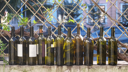 Wine bottles in a row on the fenceの写真素材