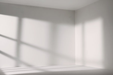 Sunlight from the window shines on the empty room walls and floorの写真素材