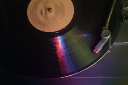 Retro record player with a spinning vinyl record reflecting color lights