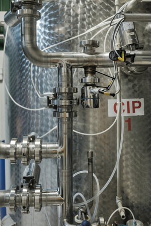 Steel pipelines, tubes and tanks at brewery. Close up of iron pipes and equipment