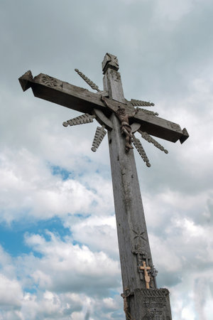 Old wooden cross on a blue cloudy sky backgroundの写真素材