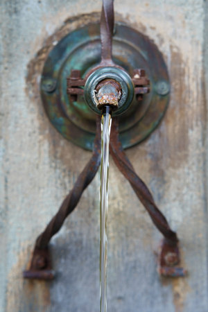 Clean water flowing from the old drinking fountain, selective focusの写真素材