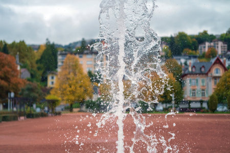 Close-up of a jet of water and splashes of a fountain in town public park, selective focusの写真素材