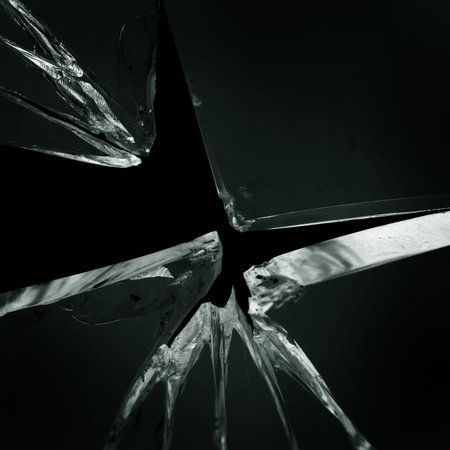 Cracked and broken glass with hole on a black backgroundの写真素材
