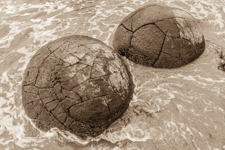 Sepia toned Moeraki boulders in a high tide. Otago, New Zealandの写真素材