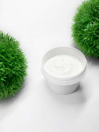 Face or body cream in a jar on white in an upright position.の写真素材