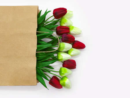 Bouquet of red and white tulips in a craft bag , on a white background with space for copyingの写真素材