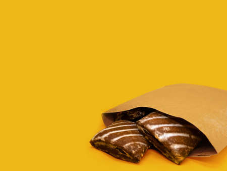 Cookies in a kraft bag on a yellow background with space for copyingの写真素材
