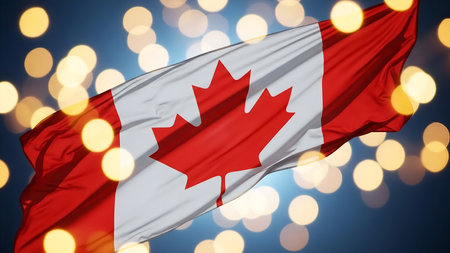 The Canadian flag with a red maple leaf in the center is waving in the wind against a blue sky with bokeh lights.の素材