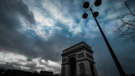 Arc de Triomphe in Paris, France with cloudy sky.