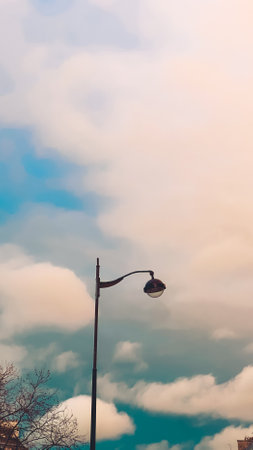 Street lamp on the background of blue sky with white clouds, vintage style. Paris, France