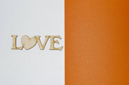 the word love half the page in wooden letters, a place for an inscription, white orange, postcardの写真素材