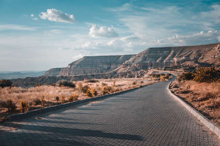 Winding mountain road along beautiful seacoast and open sea in summer. Amazing coastline natural summer scenery. Traveling, hiking, freedom and active lifestyle concept. Vintage retro tone filterの写真素材