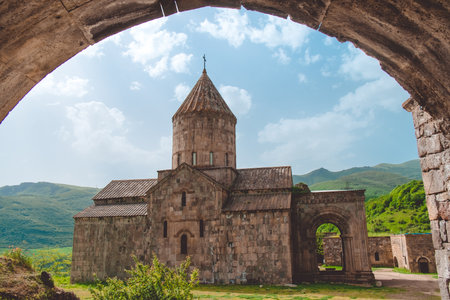 Tatev ancient monastery low view from arch. Armenia best famous travel location. Popular tourist destination. Old medieval church architecture. Mountain green hills in background. Travel, tourismの写真素材