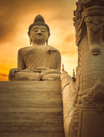 White Buddha statue in golden light. Big Buddha monument on the top of mountain of Phuket, Thailand. Tourist destination and place of Buddhist worship. Tourist travel destination. Orange tone filterの写真素材
