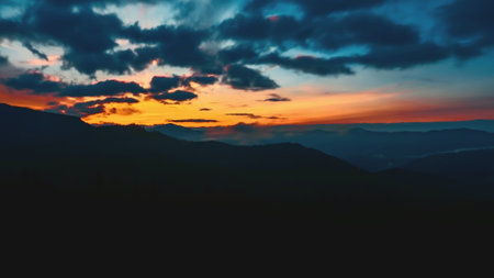 Witness the stunning transition of day to night in the Carpathian mountains as vibrant colors fill the sky during a breathtaking sunset.の写真素材