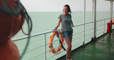 A woman standing on a boat in Thailand, ferry from Surat Thani to Koh Phangan Islandの写真素材
