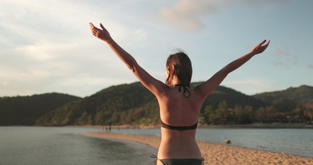 Woman in bikini is relax sandy beach of Koh Ma Beach on Koh Phangan Island in Thailand, enjoying the...