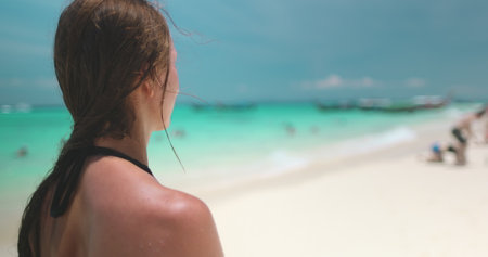 Woman enjoying a tropical vacation on phi phi islands in thailand, soaking up the sun, sand, and crystal-clear waters. 4K slow motion videoの写真素材