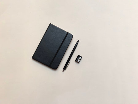 black notebook, black pen and black sharpener. On a white backgroundの写真素材