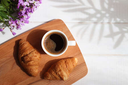 Coffee with croissants and flowers on the table. Top view. Delicious breakfast, morning concept. Copy space.の写真素材