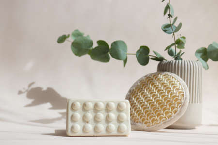 Natural cosmetics and beauty concept. Organic soap and face sponge on a light beige background. Hard light, selective focus.の写真素材