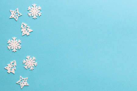Snowflakes, Christmas tree and stars on blue Christmas background with copy space