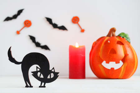 Halloween card with black cat, candle, Jack-o-latern and bats. Selective focus