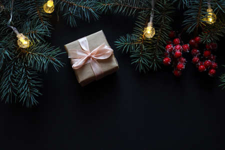 Christmas card with Christmas tree branches, Christmas socks, gifts and wooden letters MERRY CHRISTMAS on a black background. Festive and holiday background. Top view, flat lay.の写真素材
