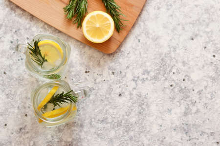 Two jars of lemonade with ice, lemon and rosemary. Copy space for text, top view, flat lay. Refreshing summer drinksの写真素材