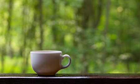 Cup of coffee or tea against lush foliage. Nature concept, relaxationの写真素材