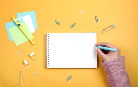 Write thoughts and ideas in a clean white notebook. Orange background