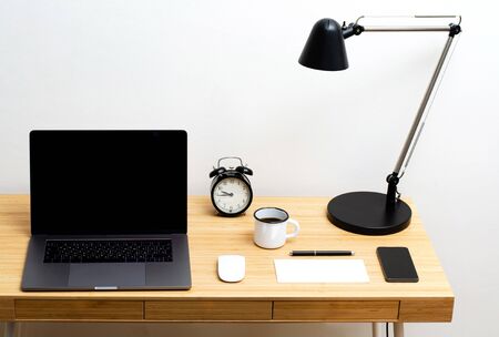 Desk. Workplace at home. On the wooden table is a glass of water, phone, alarm clock.の写真素材